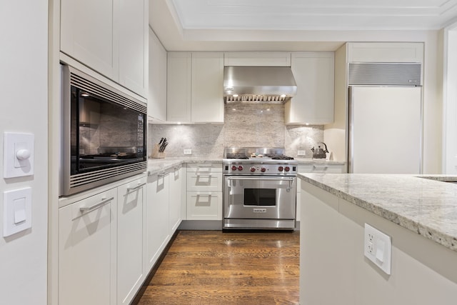 159 E Walton Pl Unit 5C, Chicago, IL 60611 - kitchen with built in appliances, wall chimney range hood, light stone countertops, and white cabinetry