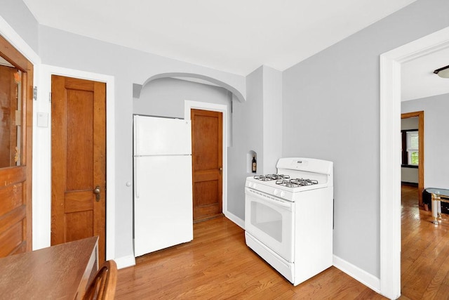 3209 S Harding Ave, Chicago, IL 60623 - kitchen featuring white appliances, light wood finished floors, and arched walkways