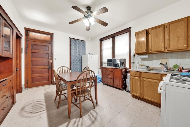 3209 S Harding Ave, Chicago, IL 60623 - kitchen with white appliances, a ceiling fan, light countertops, decorative backsplash, and brown cabinetry