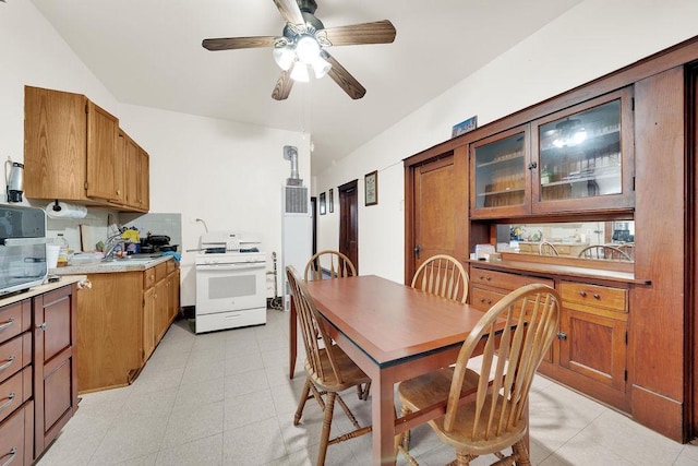 3209 S Harding Ave, Chicago, IL 60623 - kitchen with white gas range, light countertops, a ceiling fan, brown cabinetry, and vaulted ceiling