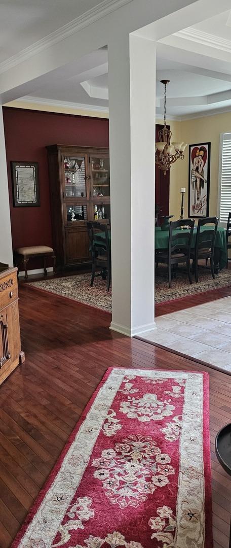 12663 Cold Springs Dr, Huntley, IL 60142 - corridor with wood finished floors, a chandelier, and ornamental molding