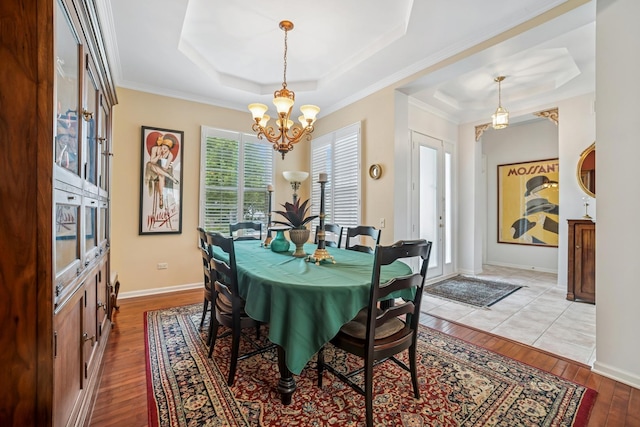 12663 Cold Springs Dr, Huntley, IL 60142 - dining area featuring a raised ceiling, a chandelier, wood-type flooring, and crown molding