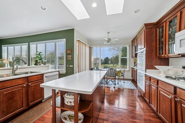 12663 Cold Springs Dr, Huntley, IL 60142 - kitchen with white appliances, light countertops, a skylight, ornamental molding, and dark wood-style flooring