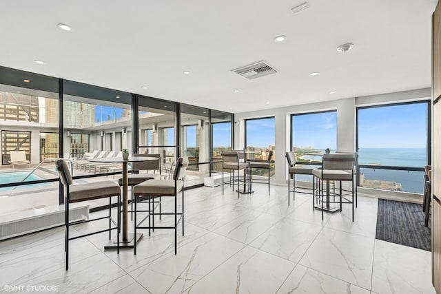 260 E Chestnut St Unit 3303, Chicago, IL 60611 - dining room with healthy amount of natural light, marble look tile flooring, a wall of windows, and a water view
