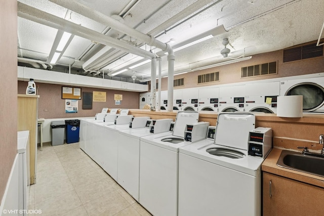260 E Chestnut St Unit 3303, Chicago, IL 60611 - shared laundry with washer and dryer and light tile patterned flooring