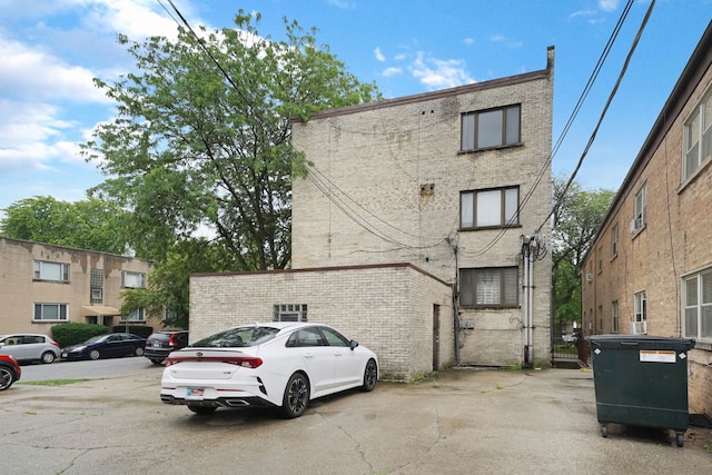 5200 N Rockwell St Unit 3N, Chicago, IL 60625 - back of property with brick siding, a gate, and uncovered parking