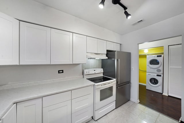 5200 N Rockwell St Unit 3N, Chicago, IL 60625 - kitchen featuring white range with electric stovetop, stacked washing machine and dryer, under cabinet range hood, freestanding refrigerator, and white cabinets