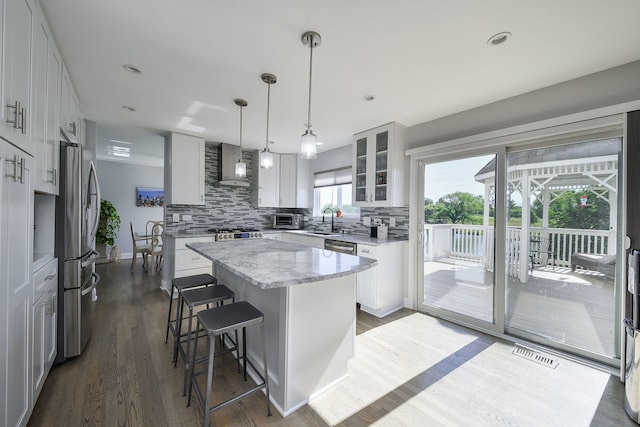 3142 Bennett Pl, Aurora, IL 60502 - kitchen with wall chimney exhaust hood, freestanding refrigerator, a center island, dark wood-style flooring, and backsplash