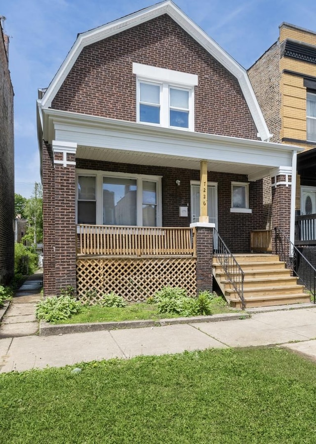 7226 S Rhodes Ave, Chicago, IL 60619 - colonial inspired home with brick siding, a gambrel roof, and a porch