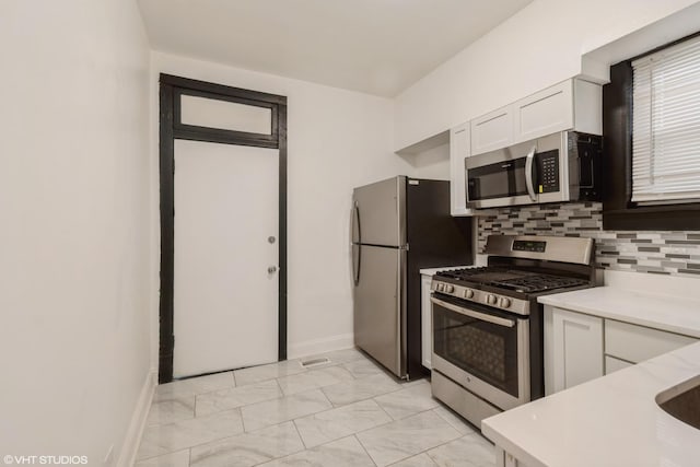 7226 S Rhodes Ave, Chicago, IL 60619 - kitchen with appliances with stainless steel finishes, light marble finish floors, white cabinetry, and light countertops