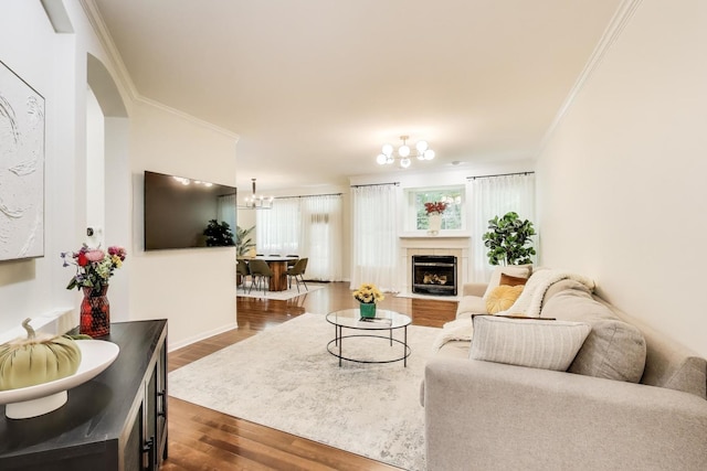 2302 Sandy Creek Dr, Algonquin, IL 60102 - living room with dark wood finished floors, ornamental molding, a chandelier, a tiled fireplace, and arched walkways