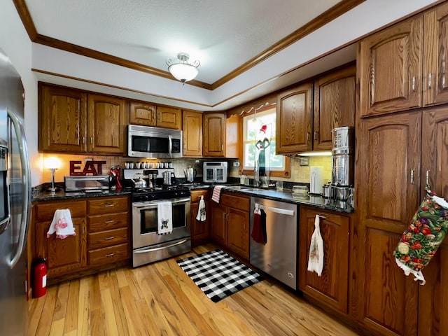 6119 Little Galilee Rd, Clinton, IL 61727 - kitchen with stainless steel appliances, crown molding, brown cabinets, backsplash, and light wood finished floors
