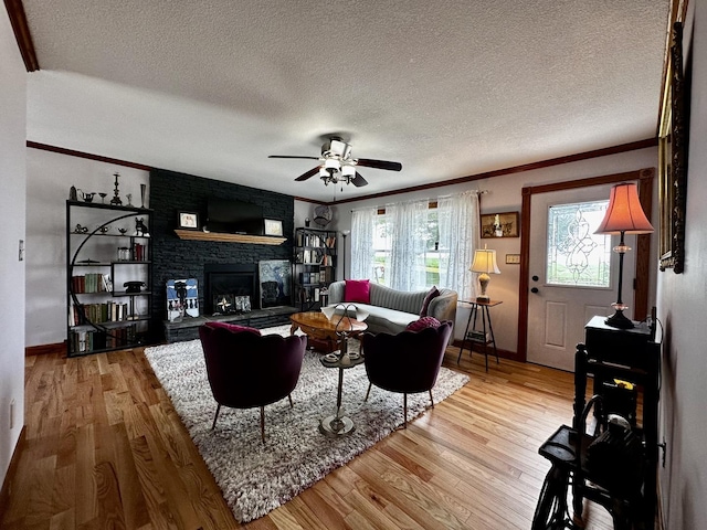 6119 Little Galilee Rd, Clinton, IL 61727 - living area with a textured ceiling, wood finished floors, crown molding, a fireplace, and a ceiling fan