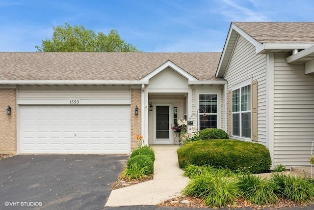 1550 W Ludington Cir, Romeoville, IL 60446 - view of front of house with an attached garage, a shingled roof, and driveway