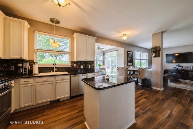 1550 W Ludington Cir, Romeoville, IL 60446 - kitchen featuring stainless steel appliances, dark wood-style floors, decorative backsplash, a center island, and white cabinets