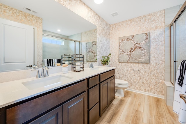12124 Kelsey Dr, Huntley, IL 60142 - full bath featuring wallpapered walls, wood finished floors, double vanity, and a shower stall