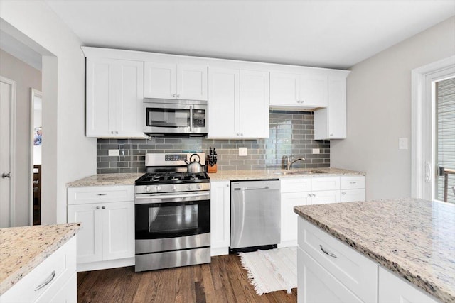 1259 Durham Dr, Wheaton, IL 60189 - kitchen with appliances with stainless steel finishes, dark wood-style flooring, backsplash, and white cabinets