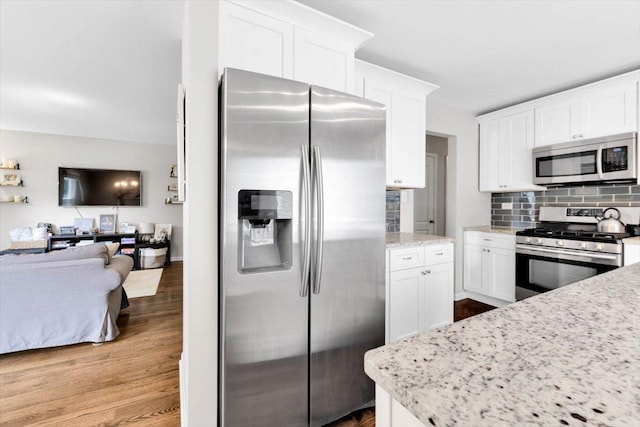 1259 Durham Dr, Wheaton, IL 60189 - kitchen with stainless steel appliances, open floor plan, backsplash, white cabinetry, and wood finished floors