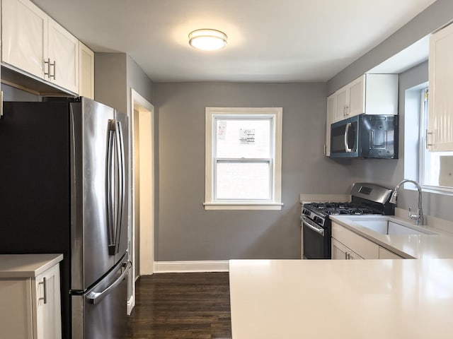 8517 S Wallace St, Chicago, IL 60620 - kitchen with stainless steel appliances, dark wood-style flooring, white cabinetry, and healthy amount of natural light