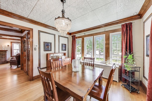 210 Berry Pkwy, Park Ridge, IL 60068 - dining room with crown molding, radiator, a chandelier, light wood-type flooring, and an ornate ceiling