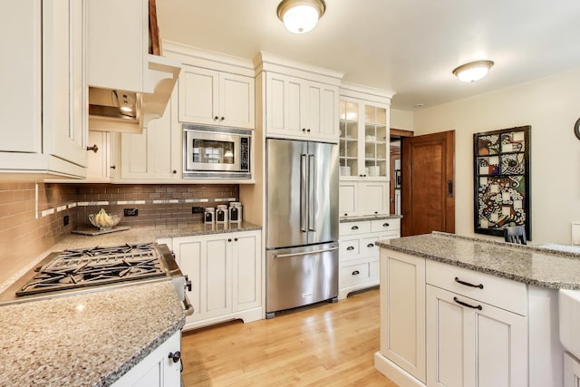210 Berry Pkwy, Park Ridge, IL 60068 - kitchen with appliances with stainless steel finishes, decorative backsplash, light wood finished floors, white cabinets, and glass insert cabinets