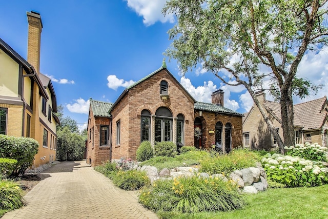 210 Berry Pkwy, Park Ridge, IL 60068 - tudor home featuring a chimney, brick siding, and a tile roof