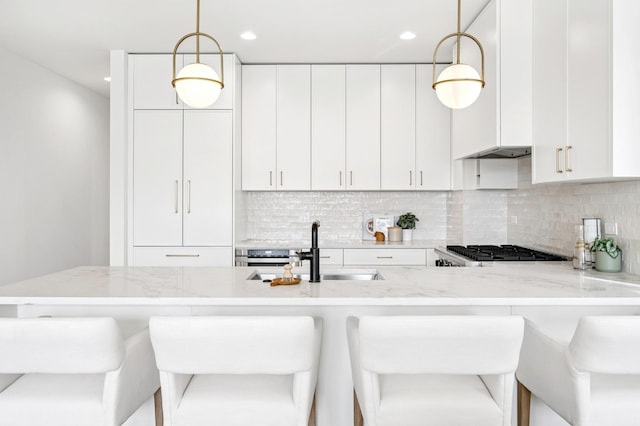 1352 W Diversey Pkwy Unit 2, Chicago, IL 60614 - kitchen featuring light stone countertops, tasteful backsplash, decorative light fixtures, ventilation hood, and recessed lighting