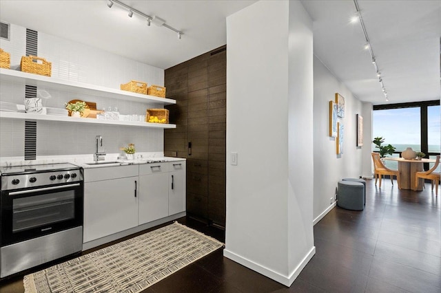 910 N Lake Shore Dr Unit 1615, Chicago, IL 60611 - kitchen with track lighting, stainless steel range oven, open shelves, backsplash, and light stone countertops