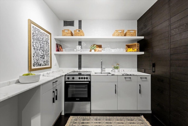 910 N Lake Shore Dr Unit 1615, Chicago, IL 60611 - kitchen with stainless steel range with electric stovetop, open shelves, decorative backsplash, and light stone countertops