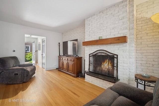 313 Hawthorn Ave Unit F, Glencoe, IL 60022 - living room featuring light wood-style floors, a brick fireplace, and brick wall