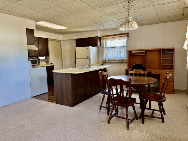 2503 Main St, Peru, IL 61354 - kitchen with freestanding refrigerator, light countertops, stainless steel microwave, under cabinet range hood, and dark brown cabinets
