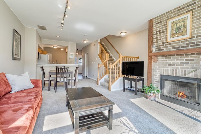 8156 Ripple Ridge Dr, Darien, IL 60561 - carpeted living area with stairs, a brick fireplace, and track lighting