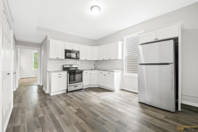 1336 Euclid Ave, Berwyn, IL 60402 - kitchen featuring appliances with stainless steel finishes, light stone counters, white cabinetry, and wood finished floors