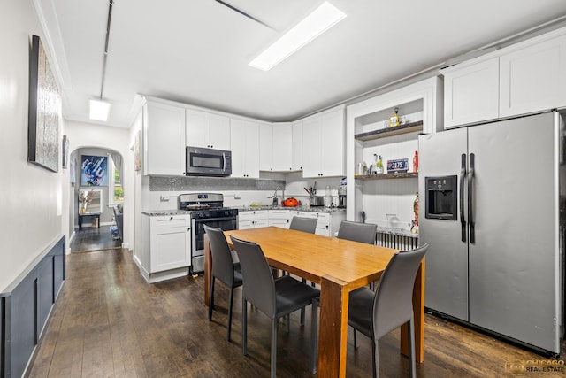 1336 Euclid Ave, Berwyn, IL 60402 - kitchen featuring appliances with stainless steel finishes, arched walkways, white cabinetry, dark wood-style flooring, and wainscoting
