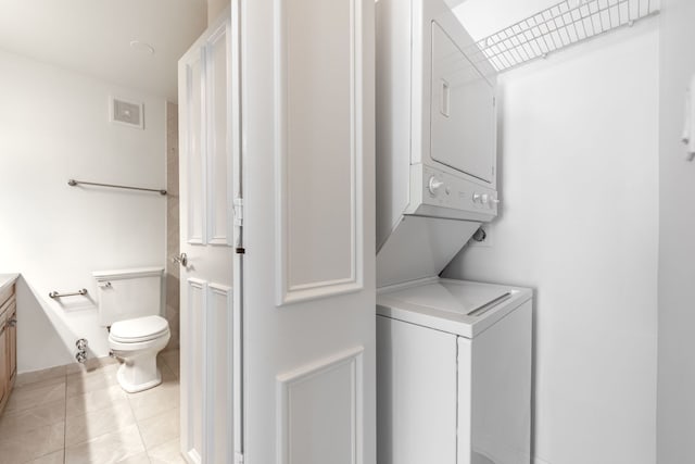 111 E Chestnut St Unit 55D, Chicago, IL 60611 - washroom featuring estacked washer and dryer and light tile patterned floors