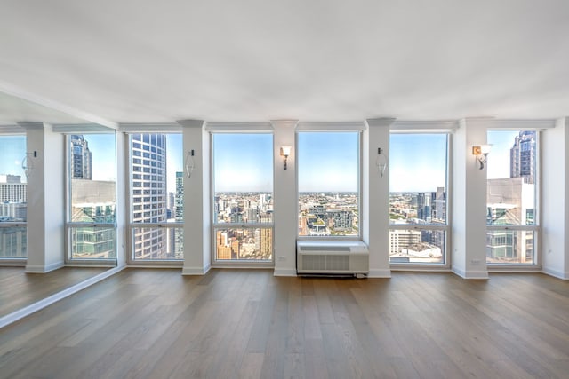 111 E Chestnut St Unit 55D, Chicago, IL 60611 - empty room with wood finished floors, a city view, and a wall unit AC
