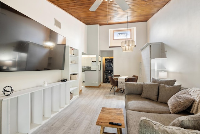 14515 Central Ct Unit Ph1, Oak Forest, IL 60452 - living room featuring estacked washer and dryer, wood ceiling, ceiling fan, light wood finished floors, and a towering ceiling