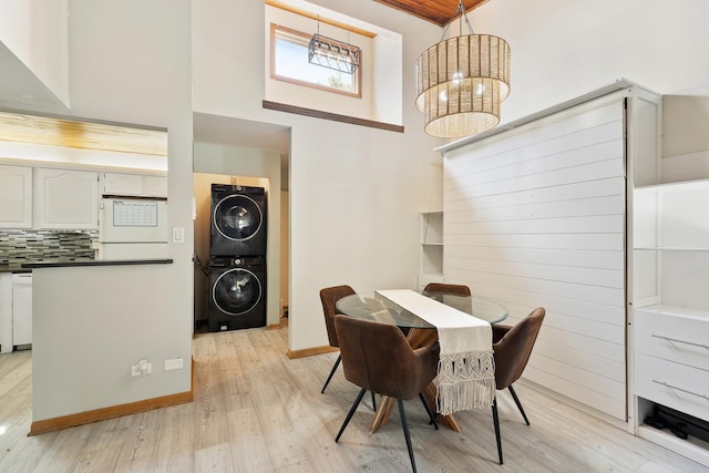 14515 Central Ct Unit Ph1, Oak Forest, IL 60452 - dining room with stacked washer / dryer, light wood-type flooring, a chandelier, and a high ceiling
