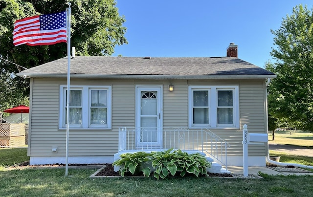 353 W Porter St, Oglesby, IL 61348 - bungalow-style home featuring a chimney, a front yard, and a shingled roof