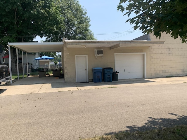 353 W Porter St, Oglesby, IL 61348 - garage featuring a carport, an AC wall unit, and concrete driveway