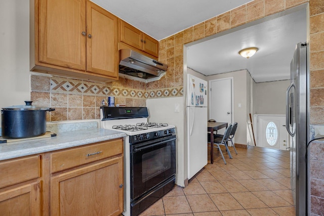 1824 Endicott Cir, Carpentersville, IL 60110 - kitchen featuring under cabinet range hood, gas stove, freestanding refrigerator, light countertops, and light tile patterned flooring