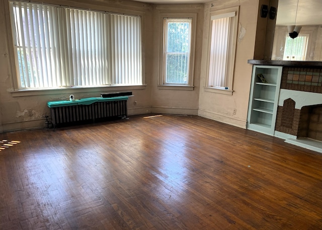 108 W 81st St, Chicago, IL 60620 - unfurnished living room featuring radiator, healthy amount of natural light, and dark wood-style floors