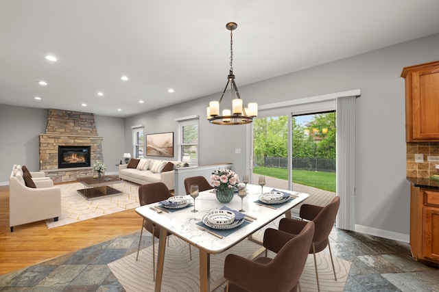 1215 Pendleton Dr, Lemont, IL 60439 - dining room with stone tile floors, recessed lighting, a chandelier, and a fireplace