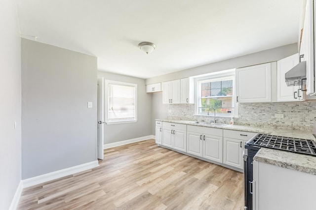 58 W 118th St, Chicago, IL 60628 - kitchen featuring stainless steel gas range oven, extractor fan, tasteful backsplash, and white cabinets