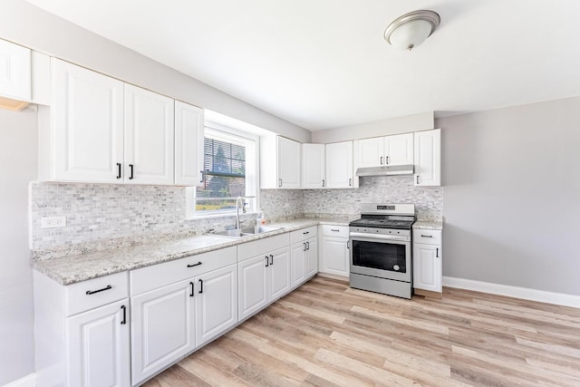 58 W 118th St, Chicago, IL 60628 - kitchen with stainless steel range with electric stovetop, under cabinet range hood, light wood-style floors, tasteful backsplash, and white cabinetry
