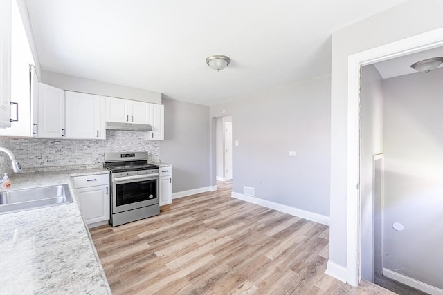 58 W 118th St, Chicago, IL 60628 - kitchen featuring electric range, under cabinet range hood, light countertops, and white cabinetry