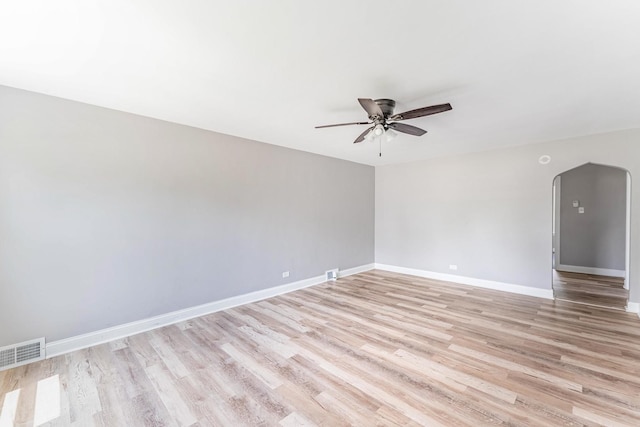 58 W 118th St, Chicago, IL 60628 - empty room with ceiling fan, arched walkways, and light wood-type flooring