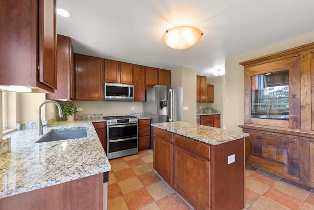 1644 Prairieview Blvd, Bolingbrook, IL 60490 - kitchen with appliances with stainless steel finishes, a center island, light stone countertops, and brown cabinetry