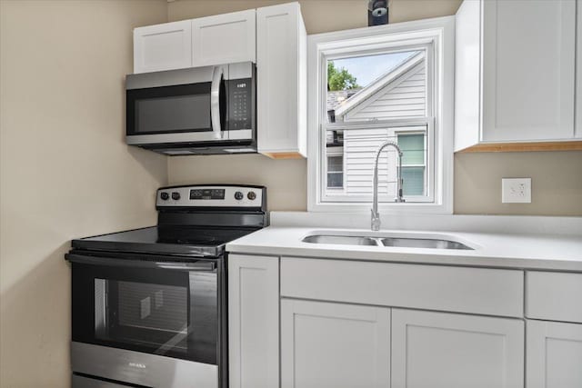 710 W Walnut St, Bloomington, IL 61701 - kitchen featuring appliances with stainless steel finishes, white cabinetry, and light countertops