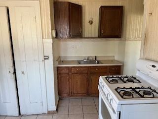 401 23rd Ave, Bellwood, IL 60104 - kitchen with white gas stove, light countertops, and light tile patterned floors
